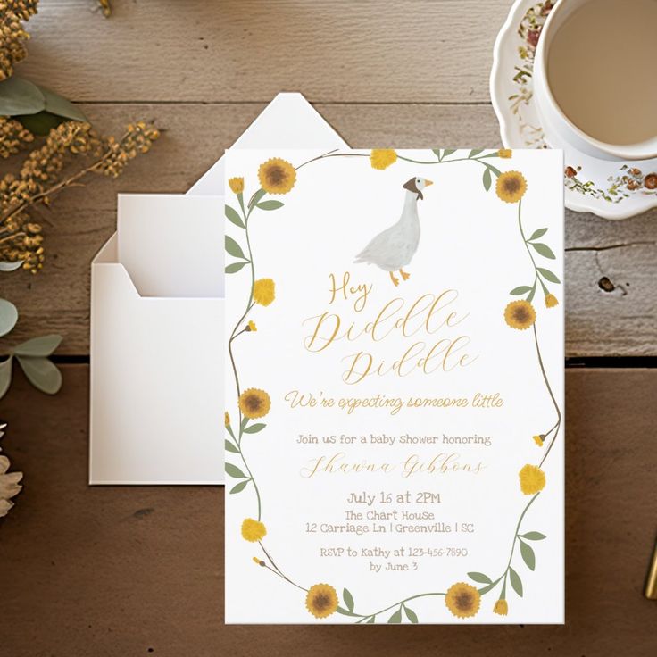 a white card with yellow flowers and a bird on it next to a cup of coffee