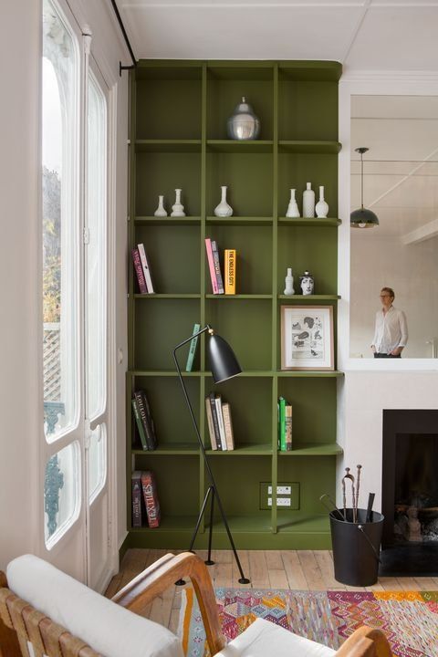 a living room filled with lots of furniture and bookshelves next to a fire place