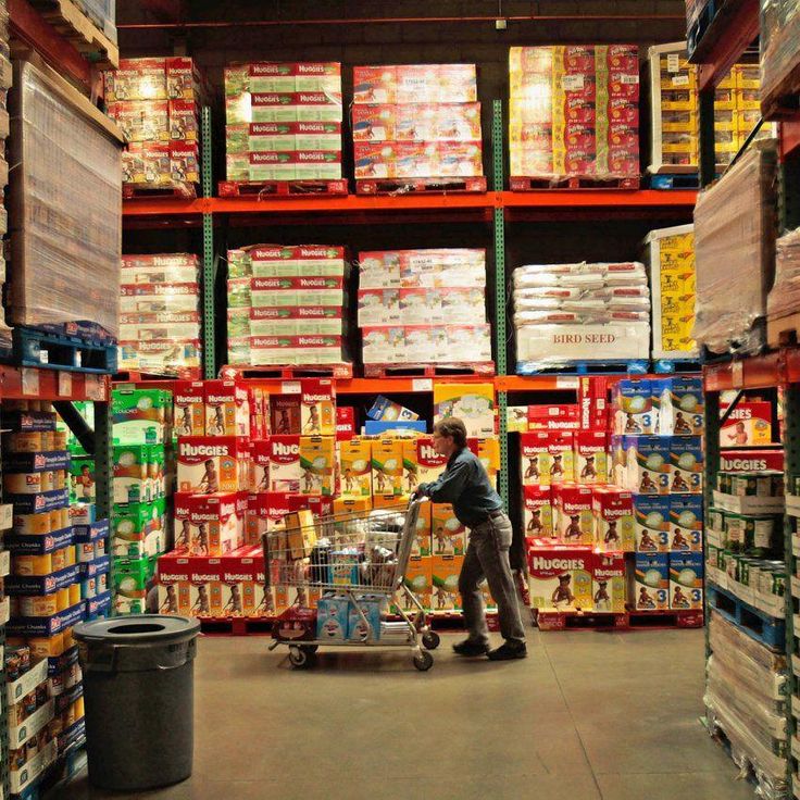 a man pushing a cart through a store filled with boxes