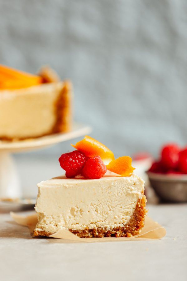 a piece of cheesecake with fruit on top and a fork next to the slice