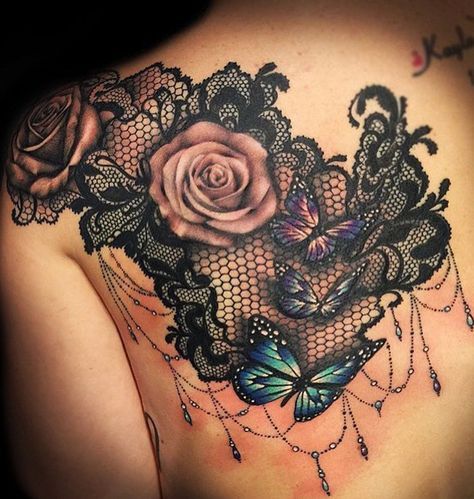 the back of a woman's shoulder with lace and roses on it, in black