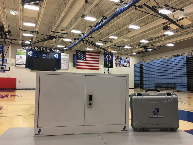 an empty basketball court with two coolers on the floor