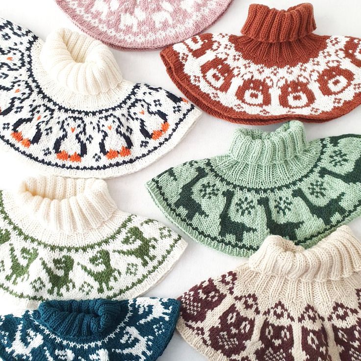 several knitted hats are arranged on a white surface