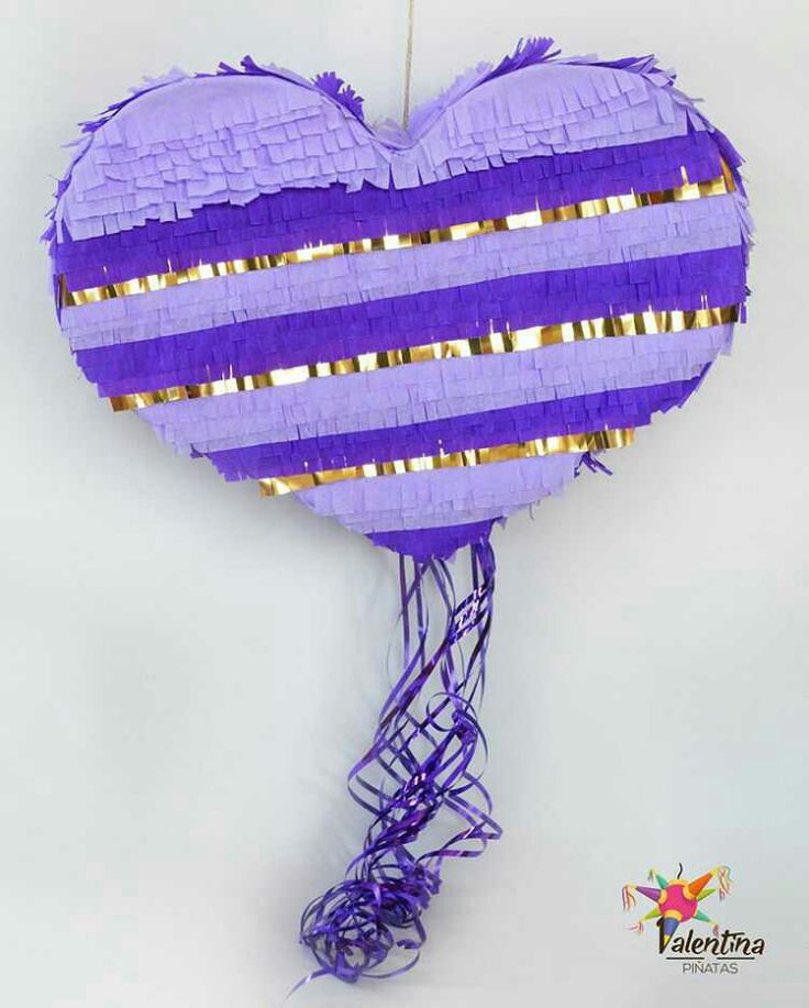 a purple heart shaped pinata hanging from a string with gold foil strips on it