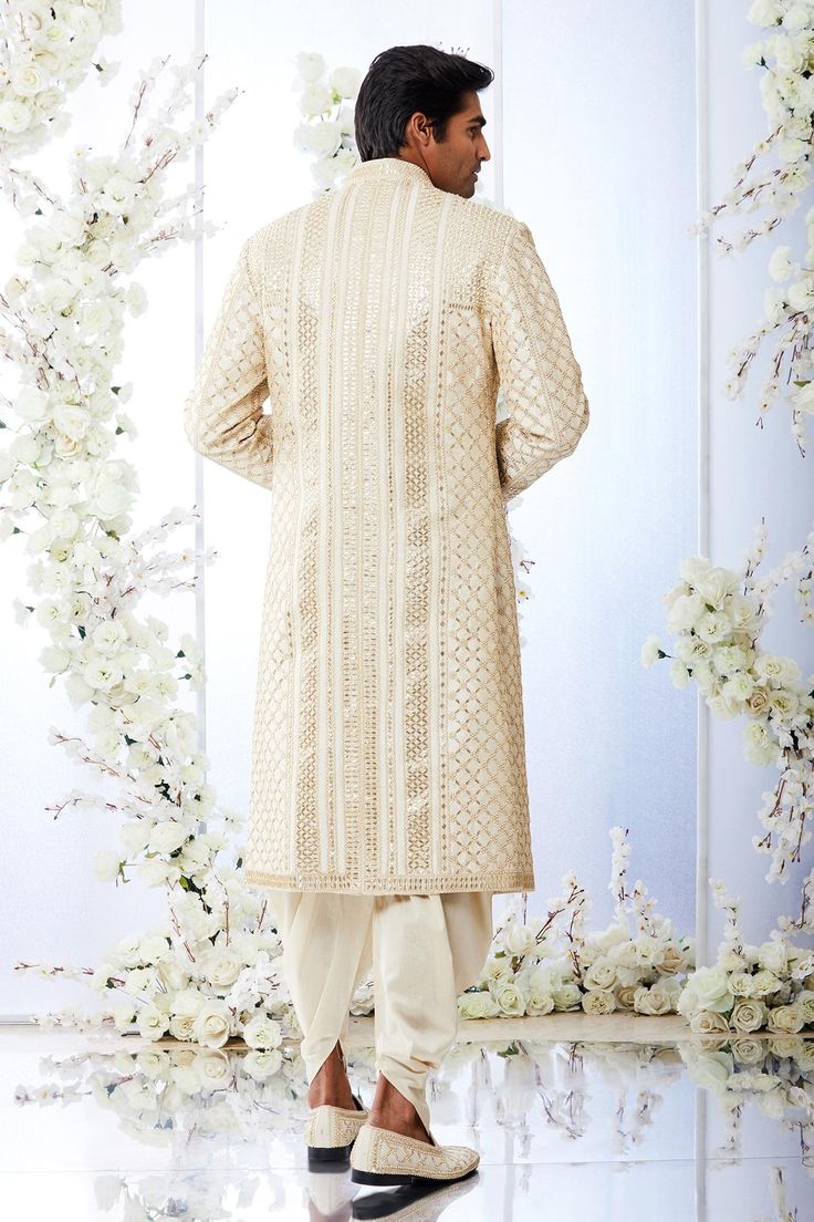 Beige sherwani features all-over gota patti embroidery on a raw silk base. Paired with a grey silk kurta and a gold twill patiala salwar.
Component: 3
Pattern: Embroidered
Type Of Work: Gota Patti 
Neckline: Mandarin
Sleeve Type: Full Sleeves
Fabric: Raw Silk
Color: Beige
Other Details: 
Gota work
Floral motifs
Note: Stole worn by the model is not for sale and Please get in touch with customer care for footwear
Occasion: Wedding, Groom - Aza Fashions Tuscan Summer, Gota Patti Embroidery, Seema Gujral, Patiala Salwar, Silk Kurta, Gray Silk, Embroidered Silk, Raw Silk, Aza Fashion