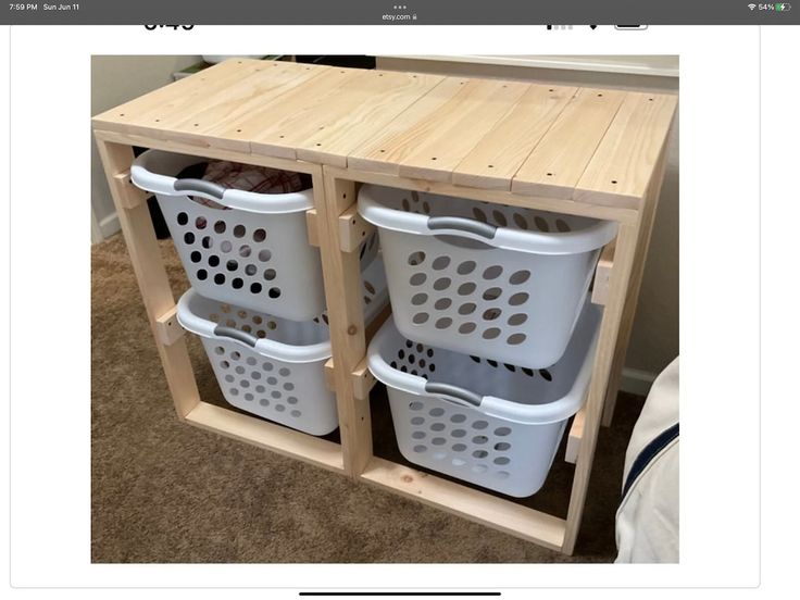 two white baskets sitting on top of a wooden shelf