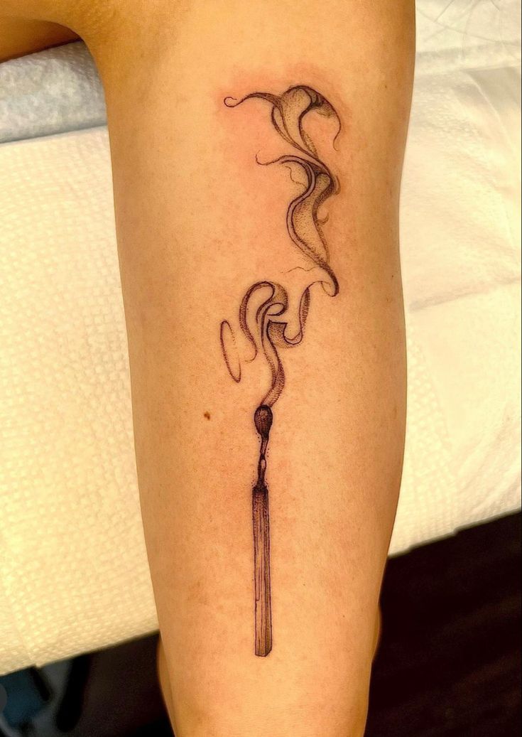 Tattoo of a half burnt match with smoke rising from it in a ribbon style placed on a person��’s lower leg Two Matches Burning Tattoo, Burning Match Tattoo Design, Survive Tattoo Symbols, Burning Paper Tattoo, Burned Match Tattoo, Smokey Match Tattoo, Matchstick Tattoo Meaning, Match Burning Tattoo, Matchstick Tattoo Design