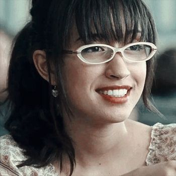 a woman wearing glasses is smiling for the camera