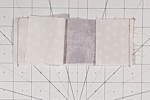 three pieces of fabric are laid out on a cutting board with lines drawn across them