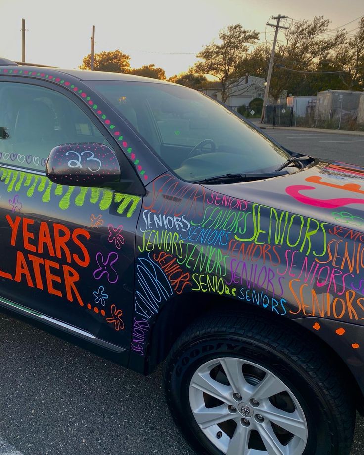 a car that has some writing on the side of it and is parked in a parking lot