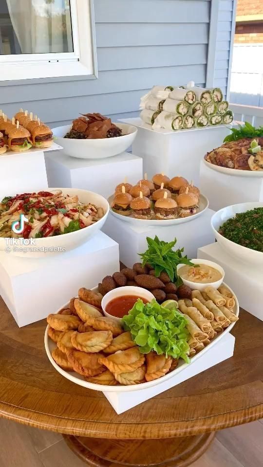 a wooden table topped with lots of plates and bowls filled with different types of food