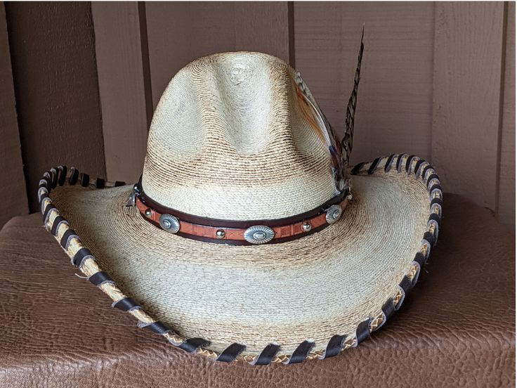 A hat for all occasions! The hat body is a very soft hat and has been flame distressed. The brim is 4" and has a wire in it to shape it further. The crown is 5". This hat has stampede strings so it stays on in those high winds. Hand laced in brown leather The layered hat band is brown leather with Southwestern imprinted whiskey brown leather and accented with sunburst sliders and nailspots. The back of the band has a deer antler bead. Finished with a long Ringneck Pheasant feather and smaller ph One Size Fits Most Sun Hat With Curved Brim, Country Style Hat With Adjustable Curved Brim, Country Style Adjustable Hat With Curved Brim, Western Style Sun Hat With Curved Brim, Adjustable Distressed Hats For Country Events, Adjustable Wide Brim Hats For Country Events, Distressed Adjustable Hats For Country Events, Adjustable Distressed Brimmed Hat, One Size Fits Most Brimmed Hats For Country Events