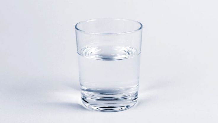 a glass filled with water sitting on top of a table