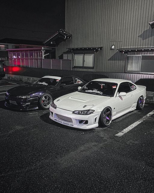 three cars parked in a parking lot at night