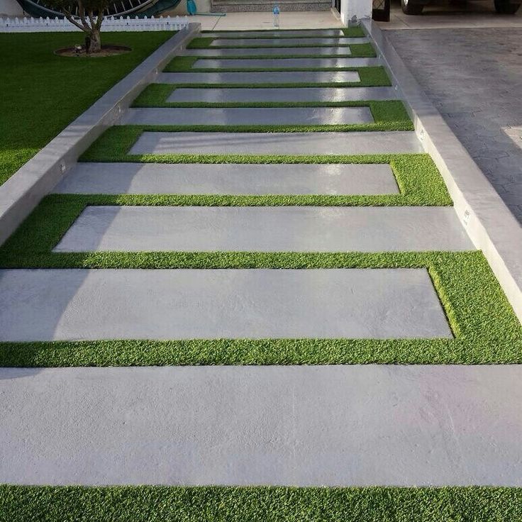 a walkway made out of concrete and artificial grass