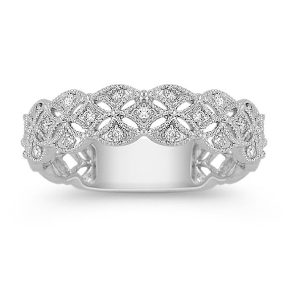 a white gold ring with diamonds on the sides and an intricate design in the middle