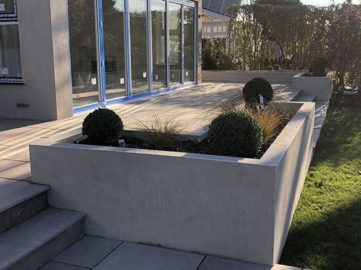 an outside view of a house with some plants in the planter and stairs leading up to it