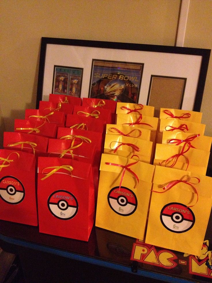 several bags with pokeball designs on them are sitting on a table in front of a framed photo