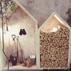 there are two houses made out of firewood and some gardening tools next to each other