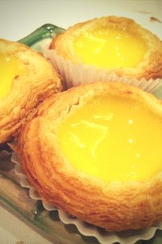 three muffins are sitting on a plate with some yellow liquid in the middle