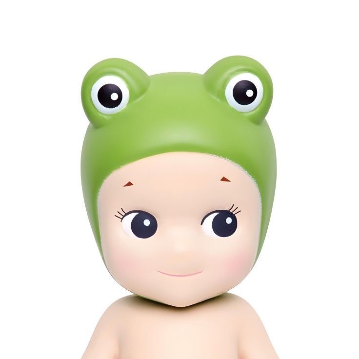 a baby doll with a green frog hat on it's head and big eyes