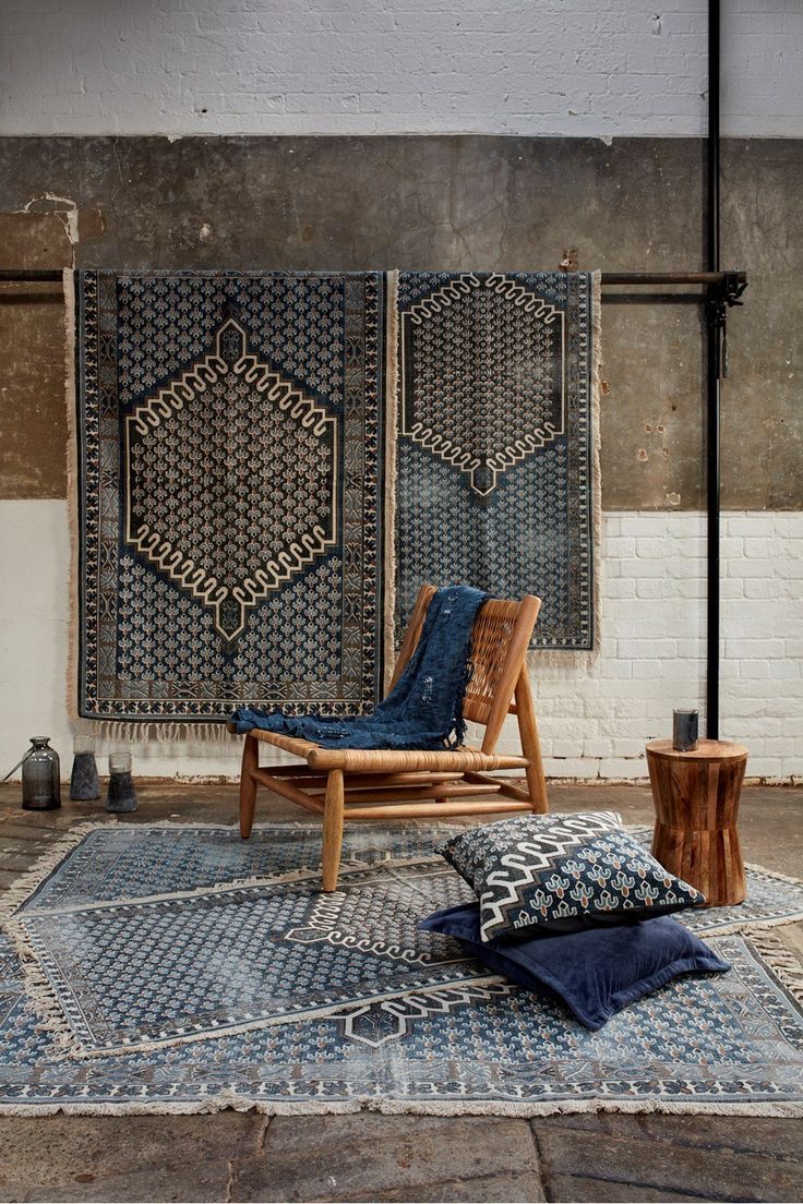 a wooden chair sitting on top of a blue rug