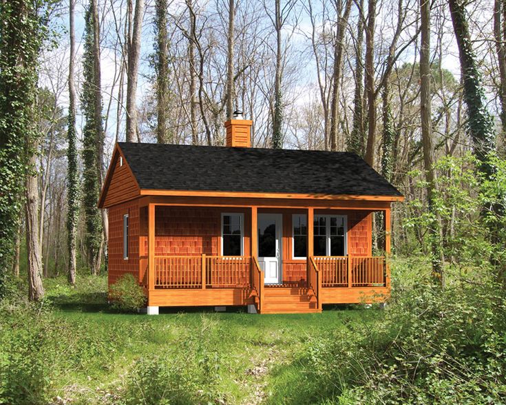 a small wooden cabin in the woods surrounded by trees