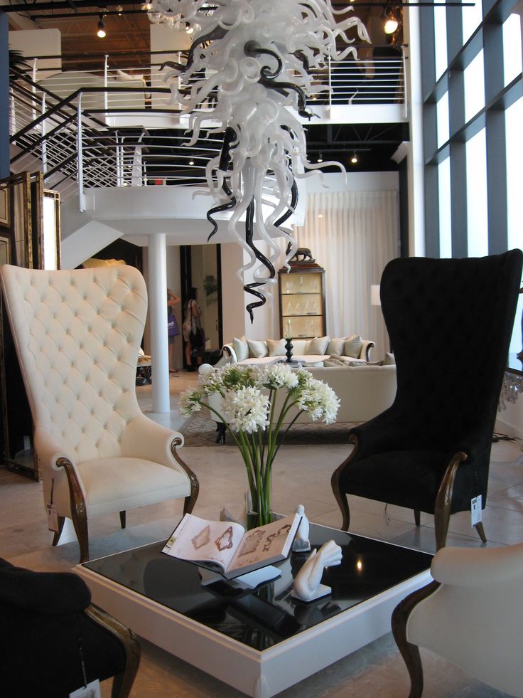 a living room filled with furniture and a chandelier hanging over the top of it