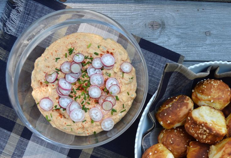 a bowl of dip and some rolls on a table