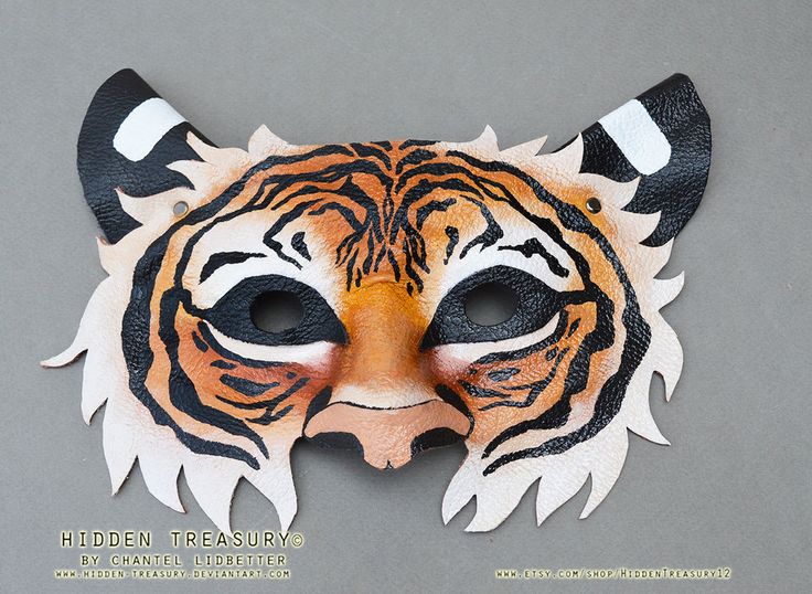 a tiger mask with black and white stripes on it's face is shown in front of a gray background