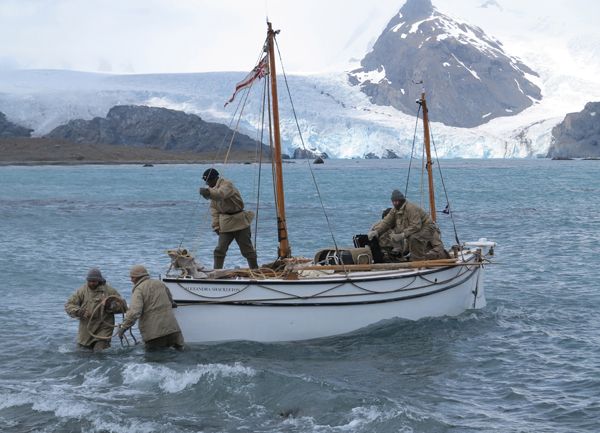 men in winter clothing are on a small boat