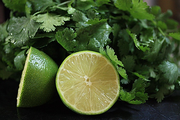 limes and cilantro on a black surface