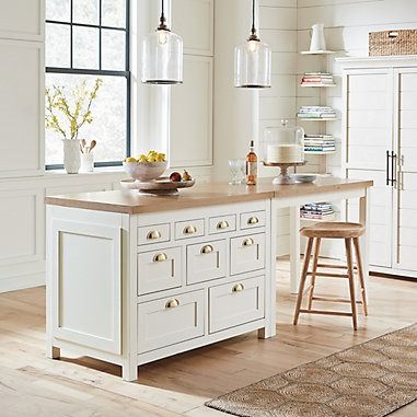 a white kitchen with an island and stools