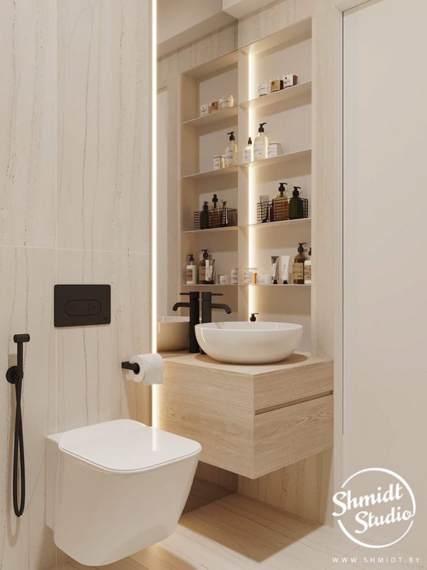 a white toilet sitting next to a bathroom sink under a faucet mounted on a wall