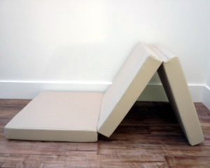 two mattresses sitting on the floor in front of a white wall