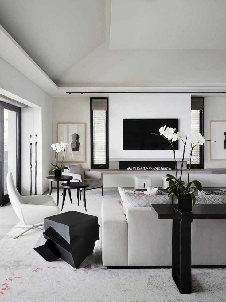 a modern living room with white furniture and black accents