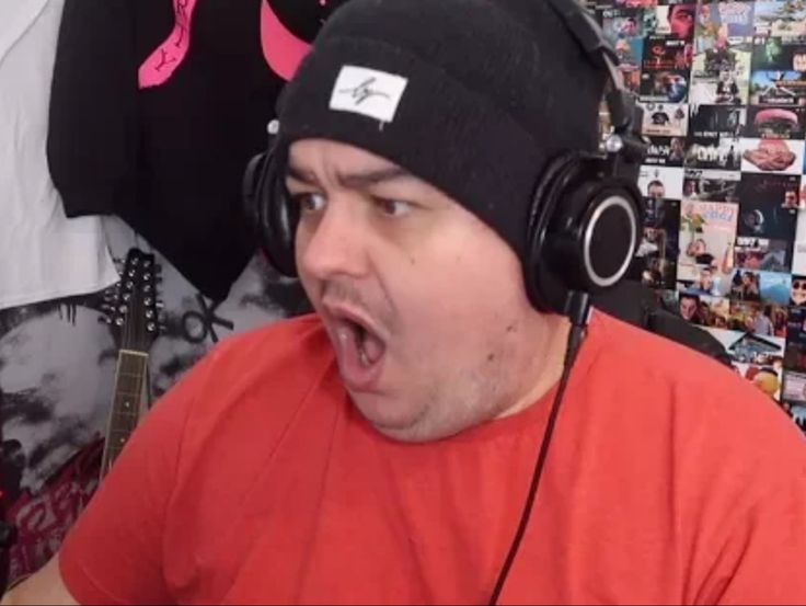 a man wearing headphones and making a surprised face