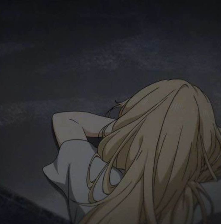 a woman with long blonde hair sitting in the dark