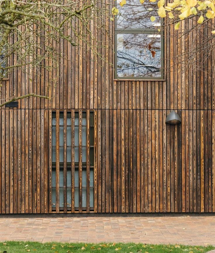 a wooden building with metal bars on the front and side walls, along with a brick walkway