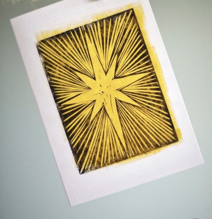 an image of a yellow starburst in the middle of a white frame hanging on a wall