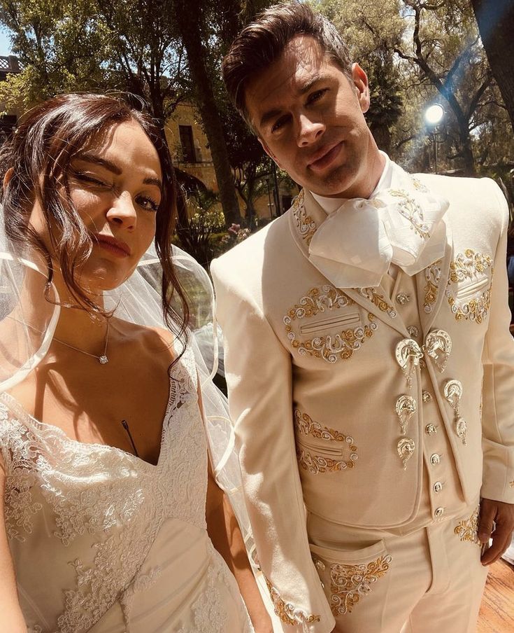 a man and woman in wedding attire standing next to each other