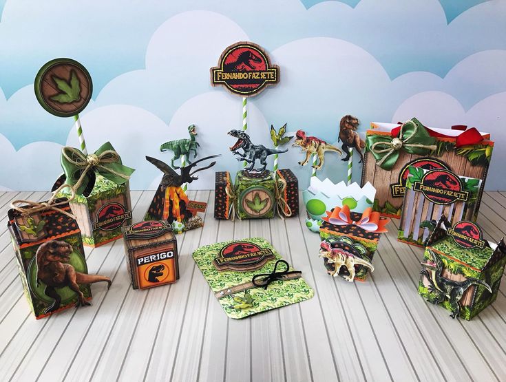 an assortment of dinosaur themed party supplies on a wooden floor with clouds in the background