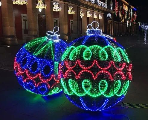 christmas lights are displayed on the street in front of buildings