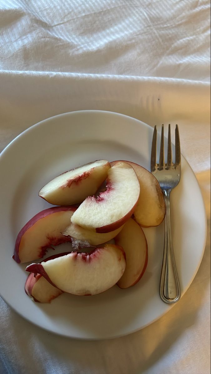 a white plate topped with sliced apples and a fork