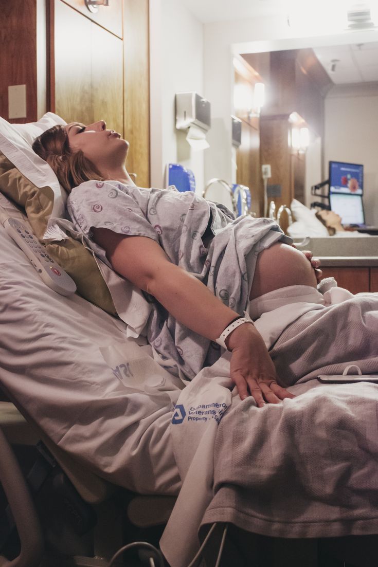 a woman laying in a hospital bed with her eyes closed