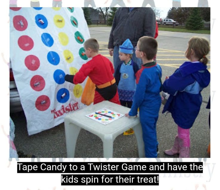 a group of children standing around a table with a giant cake on top of it