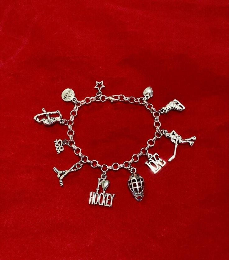 New Hockey Themed charm Bracelet Makes a Great Gift  has 11 Hockey charms all charms are approx 1/2" to 1" in size Stainless Steel bracelet has a lobster clasp closure and is adjustable measures approx 8" bracelet is Stainless Steel  charms are silver tone alloy and steel. (Nickel and lead free) charms include Star, I Love Hockey, Hockey Player, Go Team, Hockey Sticks and Puck, I Love Hockey, Hockey Helmet, Love, Hockey Player, Hockey Skates, Puffy Heart Adjustable Novelty Charm Bracelet, Personalized Novelty Charm Bracelet, Adjustable Novelty Charms Bracelets, Adjustable Themed Charms Jewelry, Adjustable Metal Charm Bracelet With Removable Charms, Novelty Charms Bracelet Jewelry, Novelty Jewelry Charms Bracelet, Themed Adjustable Jewelry With Dangling Charms, Adjustable Themed Jewelry With Dangling Charms