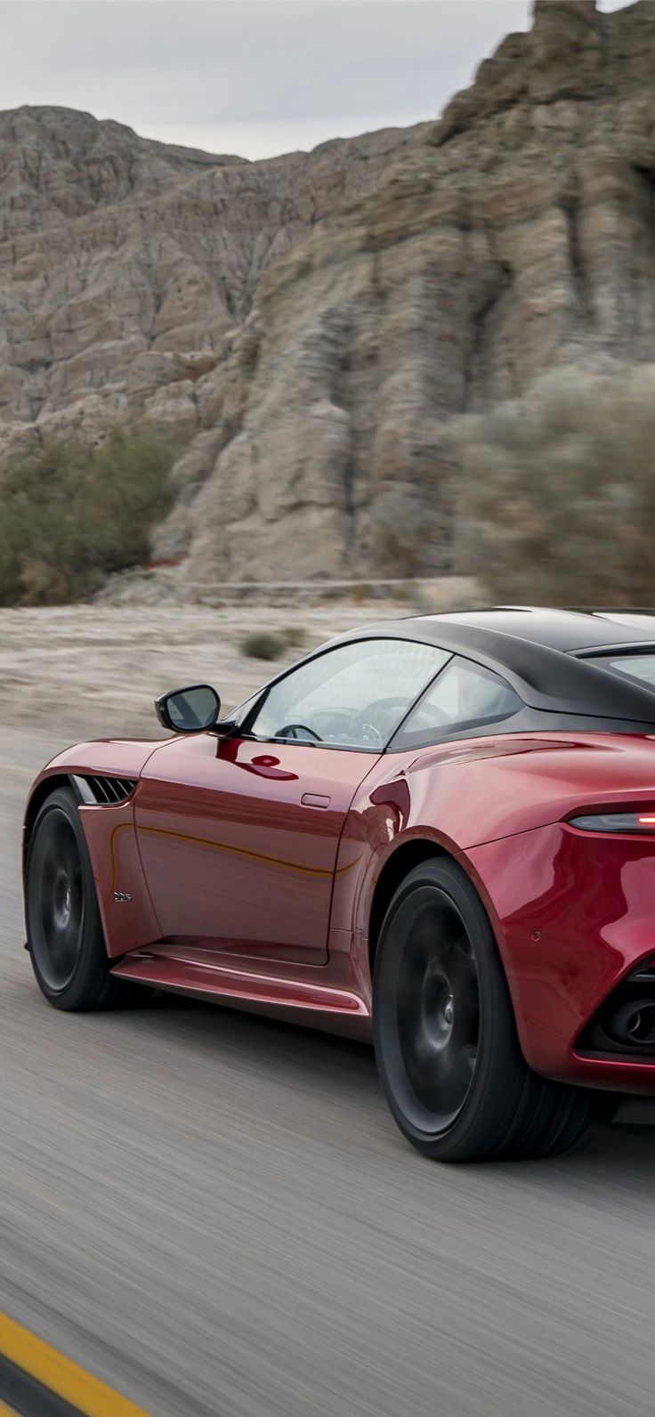 a red sports car driving down the road