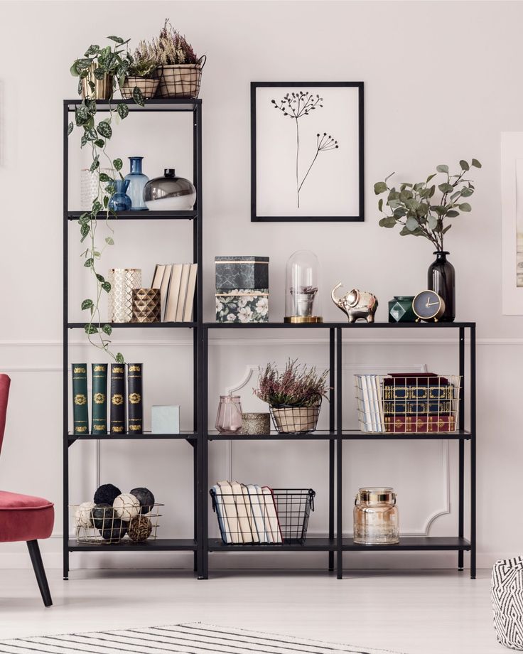 a living room filled with lots of furniture next to a wall mounted bookshelf