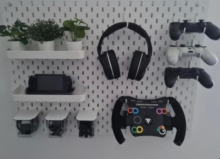 there are several video game controllers on the wall next to shelves with plants in them